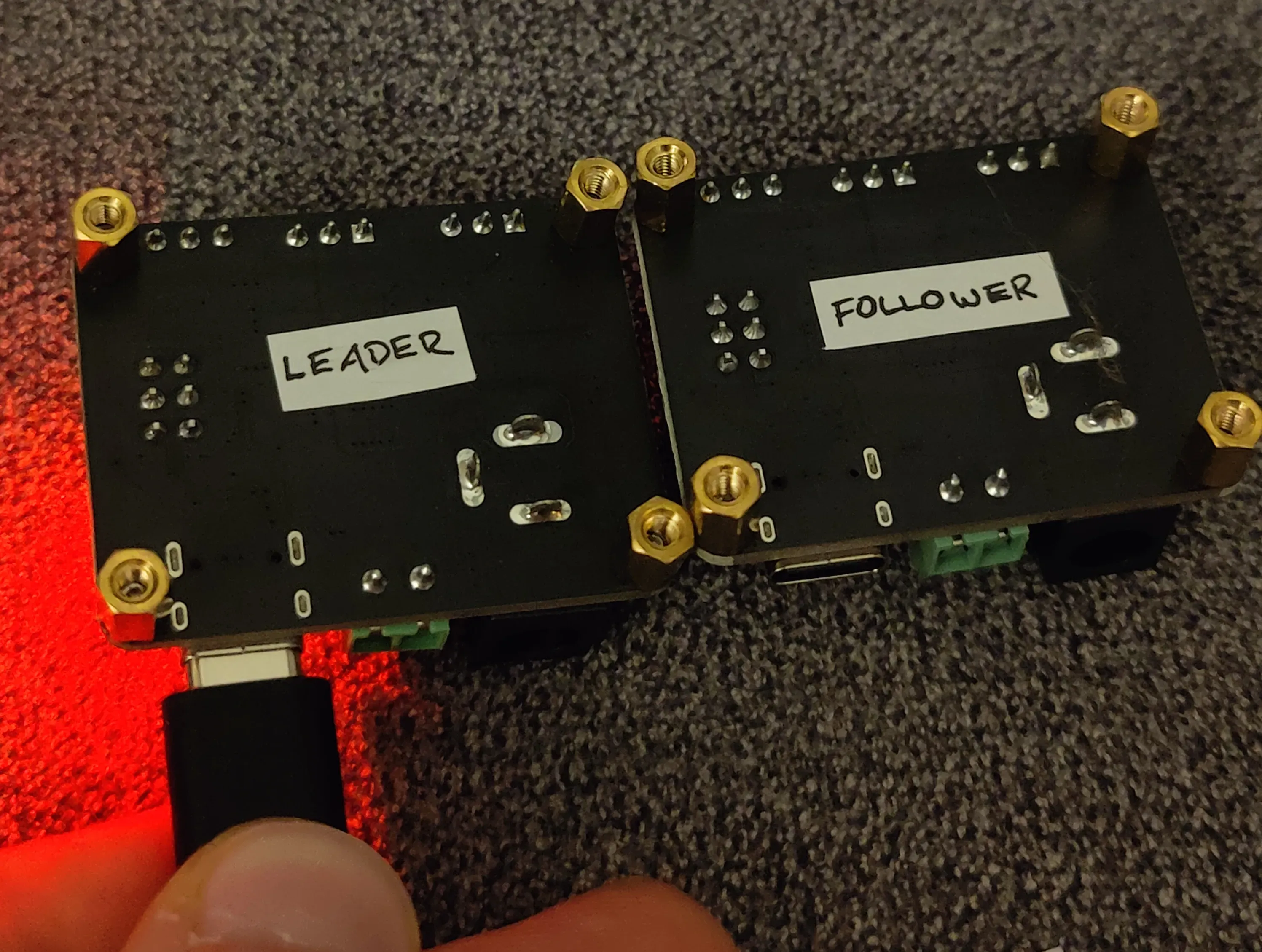 Two servo bus driver boards, one labelled LEADER and one labelled FOLLOWER